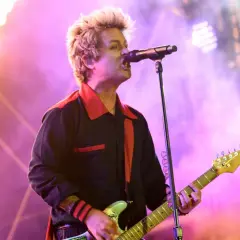 Billie Joe Armstrong von Green Day rockt die Bühne beim Rock am Ring Festival, umgeben von Flammen und lila Licht.