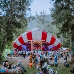Bunte Menge feiert auf dem Shambhala Festival unter einem rot-weißen Zeltdach.