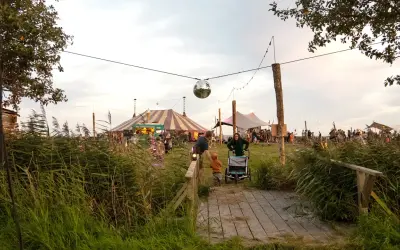 Ein buntes Zirkuszelt und Menschenmassen beim Calluna Festival. Eine Discokugel funkelt über dem Gelände.