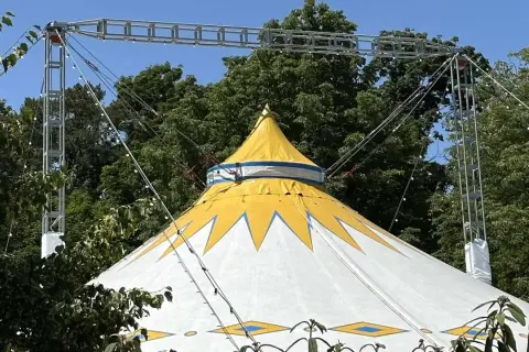 Gelbes und weißes Zirkuszelt mit Sternenmuster, das auf ein Sommerfest im Kulturzelt Kassel hindeutet.