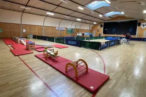 Gerätelandschaft im TSG Bewegungszentrum: bunte Matten, Wippe, Kletterbogen und mehr laden zum Toben ein.