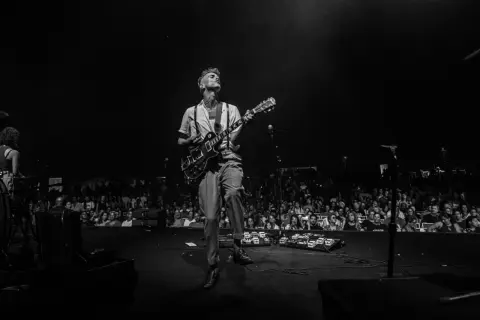 Asaf Avidan spielt in Berlin. Ein Mann mit Gitarre auf der Bühne, das Publikum im Hintergrund.