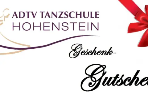 Tanzschule Hohenstein: Ein Geschenkgutschein, verpackt mit einer roten Schleife, wartet darauf, Freude zu schenken.