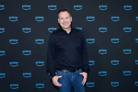 Sebastian Fitzek lächelt vor einer "prime" Kulisse, bereit für seine Fitzek Thriller Tour.