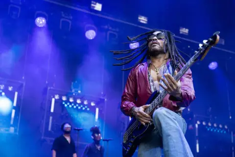 Lenny Kravitz 2023 rockt die Bühne mit seiner Bassgitarre, die Dreadlocks fliegen im Scheinwerferlicht.