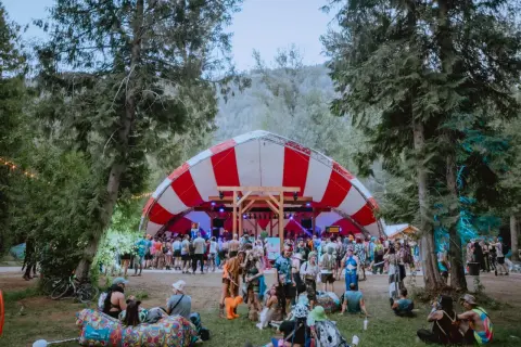 Bunte Menge feiert auf dem Shambhala Festival unter einem rot-weißen Zeltdach.
