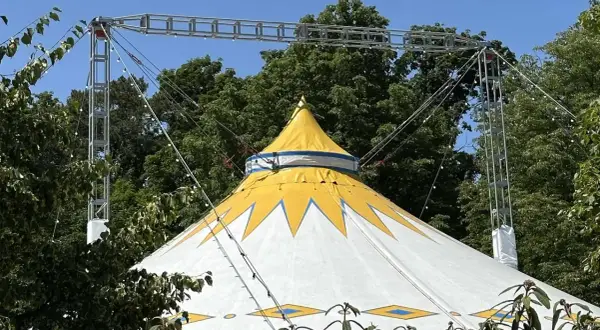 Gelbes und weißes Zirkuszelt mit Sternenmuster, das auf ein Sommerfest im Kulturzelt Kassel hindeutet.