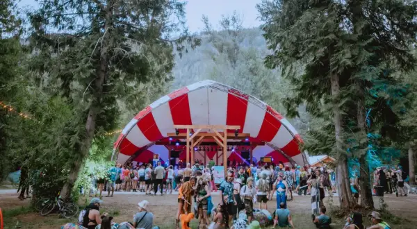 Bunte Menge feiert auf dem Shambhala Festival unter einem rot-weißen Zeltdach.