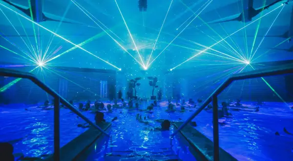 Blaue Laserstrahlen tanzen über einem Pool voller Menschen. Ein unvergessliches Erlebnis bei den Veranstaltungen in Bad Windsheim.