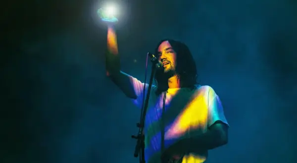 Kevin Parker von Tame Impala in Frankfurt, mit einem Lichtstrahl in der Hand.