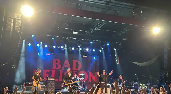 Bad Religion rockt die Bühne in Hamburg! Die Band gibt alles, während die Fans jubeln und die Hände zum Himmel recken.