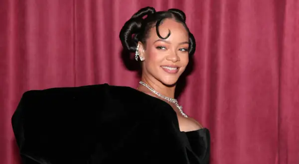 Rihanna lächelt in die Kamera, ihr Haar ist zu zwei eleganten Knoten hochgesteckt. Man fragt sich, ob sie bald ein neues Lied veröffentlicht.