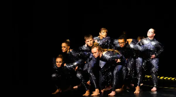 Tänzer in glitzernden Outfits, bereit für einen energiegeladenen "Diesel Disco"-Auftritt.