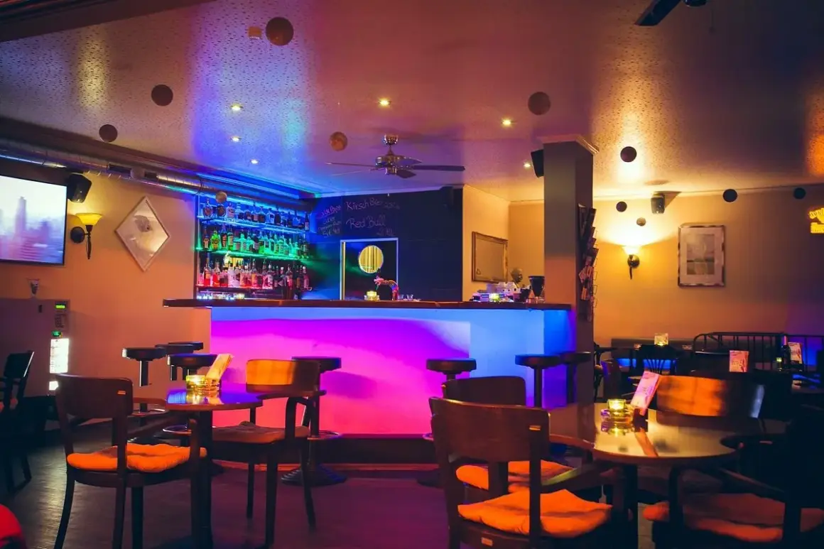 Gemütliche Bar mit bunter Beleuchtung, vielen Flaschen hinterm Tresen und Tischen. Hier kann man im "Liberté Heilbronn" entspannen.