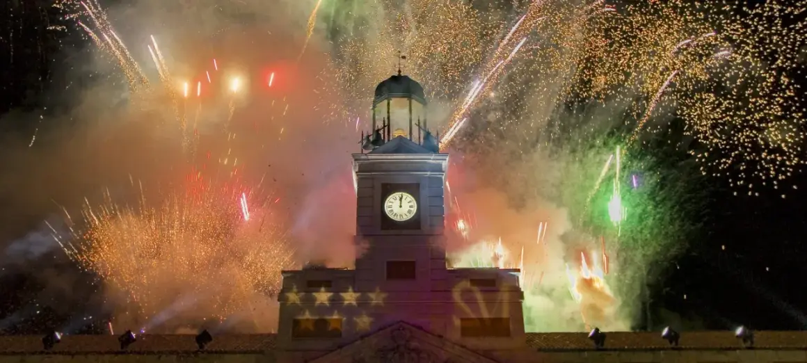 Feuerwerk erhellt den Himmel über dem Uhrturm, während der Countdown in Madrid beginnt.