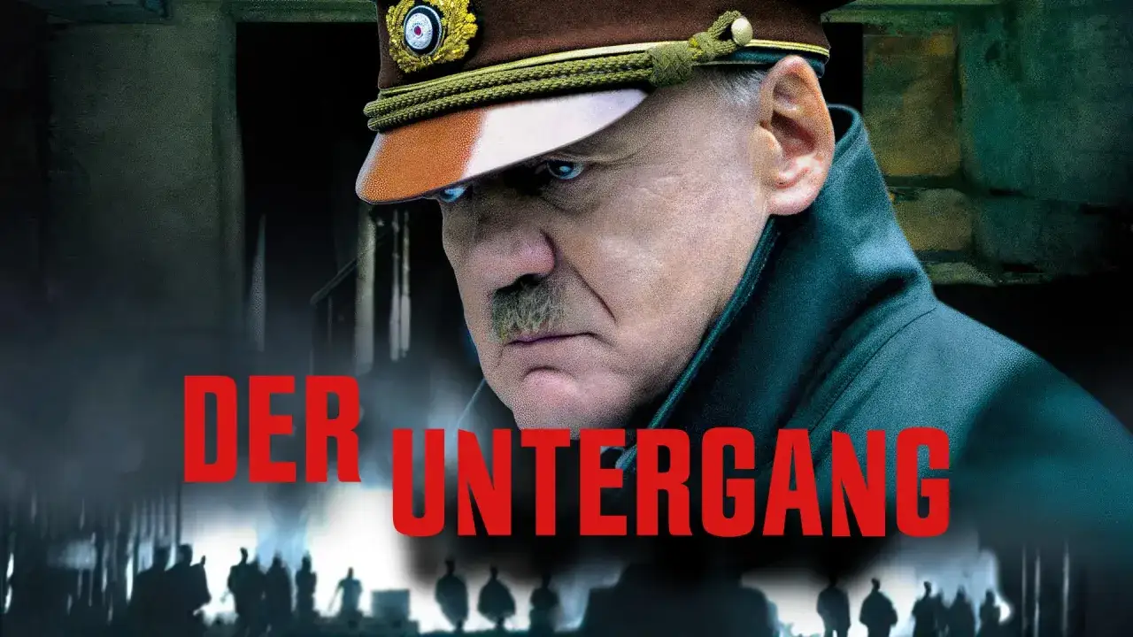 Der Untergang: Ein Mann mit Schnurrbart und Uniform blickt d&uuml;ster. Im Hintergrund schemenhafte Figuren.