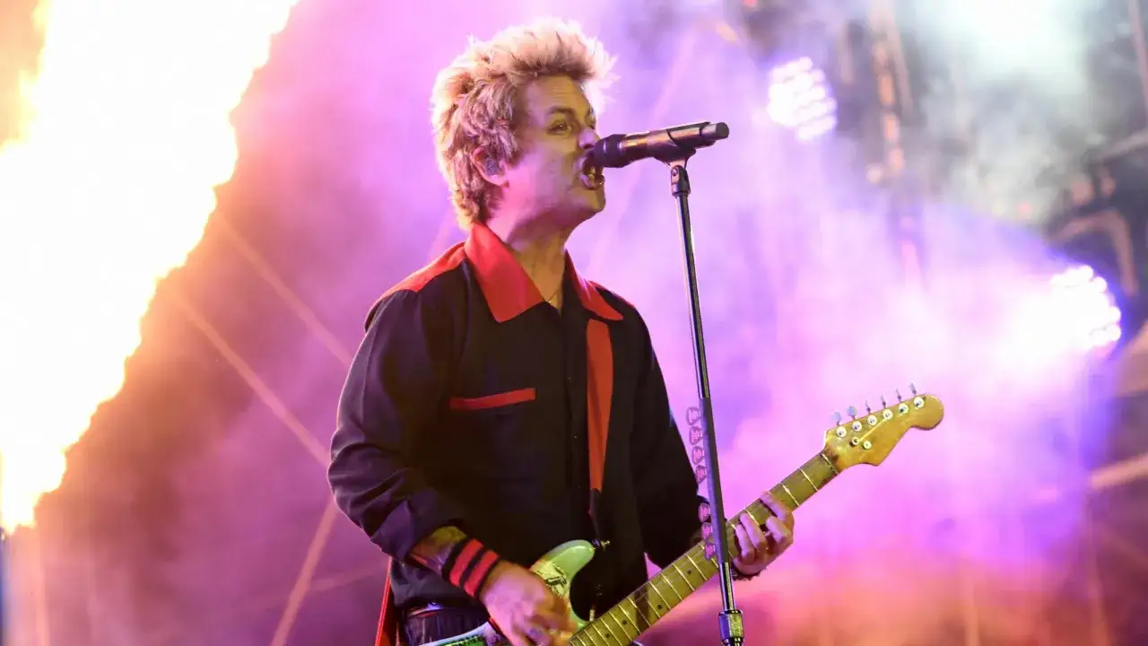 Billie Joe Armstrong von Green Day rockt die B&uuml;hne beim Rock am Ring Festival, umgeben von Flammen und lila Licht.